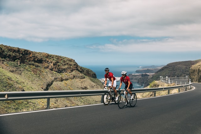 Cyclists riding a mountain by the sea